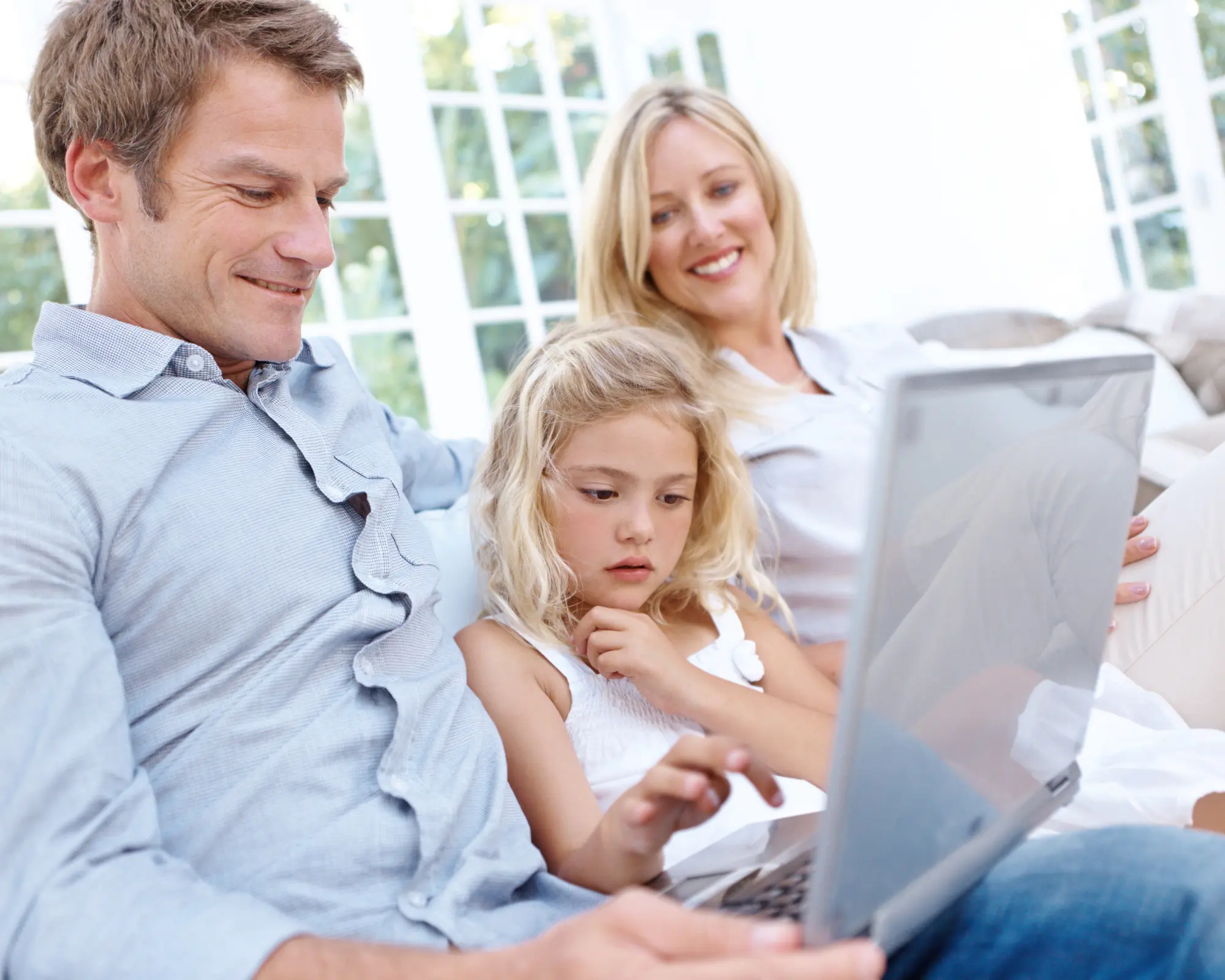 A family supporting a child while learning online together